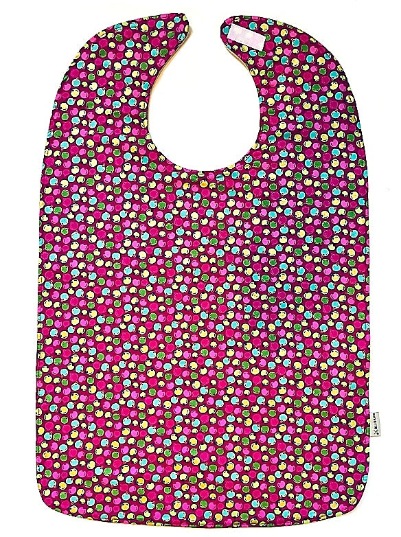 BAVETTE holiday-themed adult cotton bib features pink, red, green and yellow ornaments.